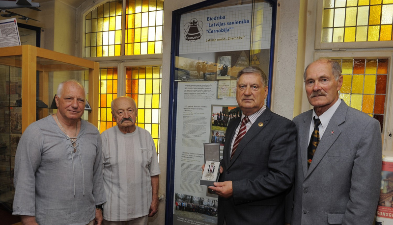 Māris Šops apbalvots ar VUGD Jubilejas goda zīmi “Latvijas Ugunsdzēsībai – 160”. Foto uzņemts pie muzejā jaunatklātā stenda “Biedrība ‘Latvijas savienība Černobiļa"