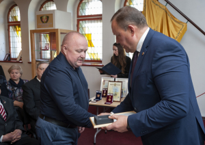 iekšlietu  ministrs pasniedz apbalvojumu