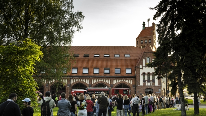 Fonā muzejs. Cilvēki stāv rindā, lai iekļūtu Latvijas Ugunsdzēsības muzejā. 