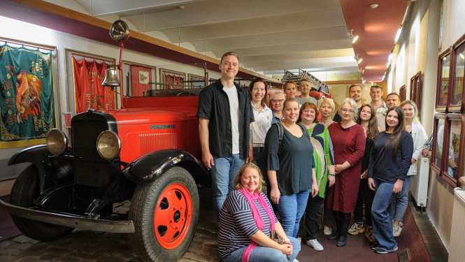 Pārvaldes kolektīvs Vēstures zēlē pie ugunsdzēsības automašīnas