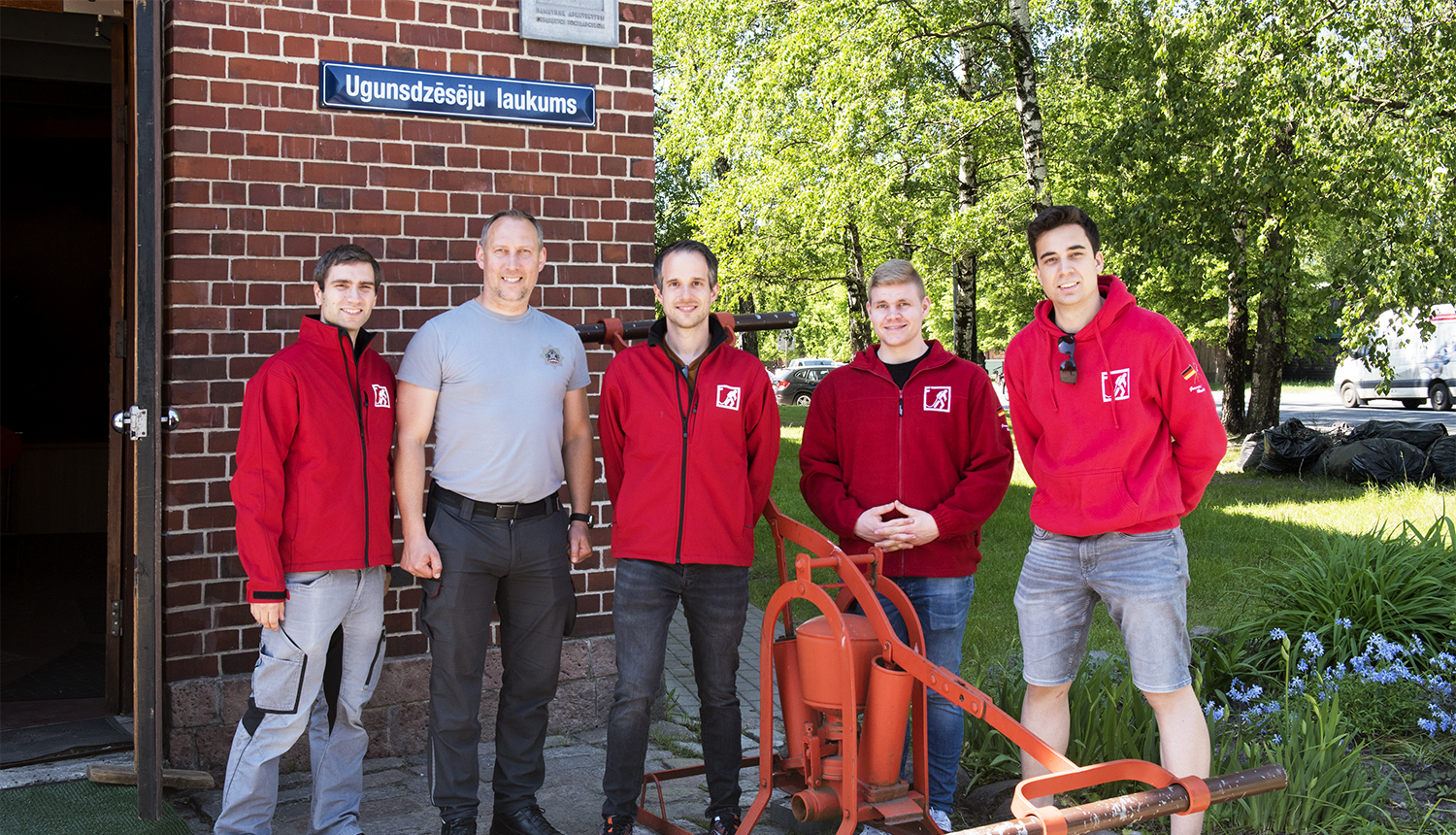 Pie muzeja ieejas durvīm  pieci ugunsdzēsēji civilapģērbā